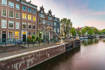 Naklejka premium Amsterdam streets, canals during dusk on the Sint Antoniesluis