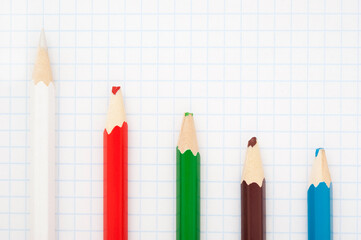 sharp  white pencil and blunt colored pencils on a writing-book leaf