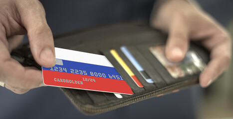 Man pulls credit card with flag of Russia out of his wallet, fictional card number