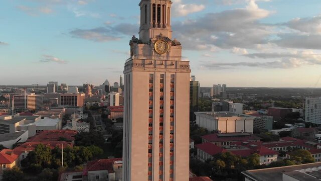 Slow drone shot of the UT tower with the hill country and downtown in the background.