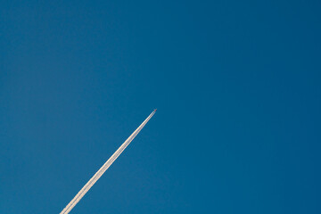 A long trail of jet plane on blue sky