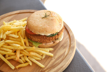 Delicious beef burger and fried potato on wooden board