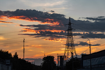 High-voltage power lines over sunset background