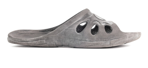 one used cheap black soft rubber slipper with signs of friction wear isolated on white background