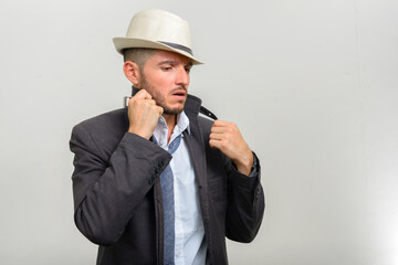 Portrait of handsome bearded Hispanic businessman wearing hat