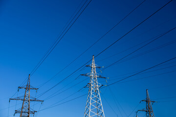 Modern high voltage towers against blue sky