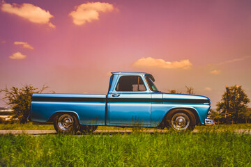 Side view of an old classic car on the street. Retro style photo of an american oldtimer pick-up...