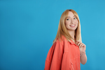 Fototapeta premium Beautiful young woman with blonde hair on blue background. Space for text