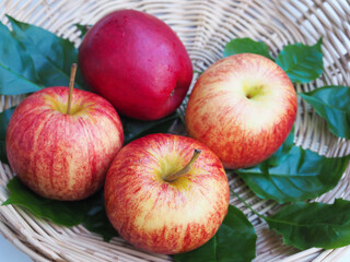 healthy food with apples red fruit in bamboo baskets and green leaves