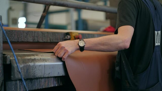 Brown leather hide on roller coating machine in factory