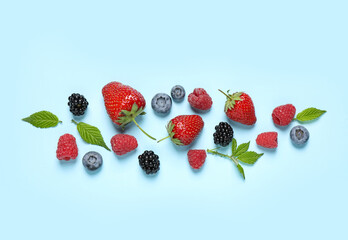 Different fresh berries on light blue background, flat lay