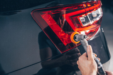 Professional detailing of a modern car or rear lights, varnish polishing lacquer, cleaning car