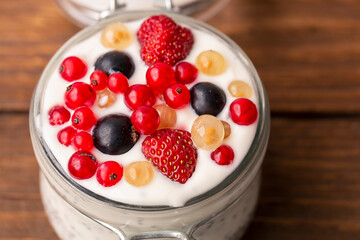 Yogurt with berries on a wooden table background. Diet, weight loss. Healthy lifestyle.