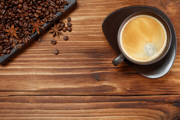 Cup of coffee and coffee beans on a wooden background. Copy space