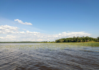 calm lake water surface, beautiful white cloud reflections in the water, sunny summer day