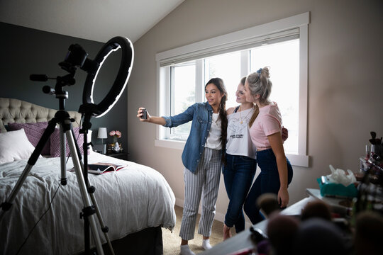 Teenage girls vlogging, taking selfie in bedroom