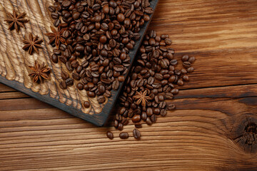 Aroma roasted coffee beans and star anise on wooden background. Top view.