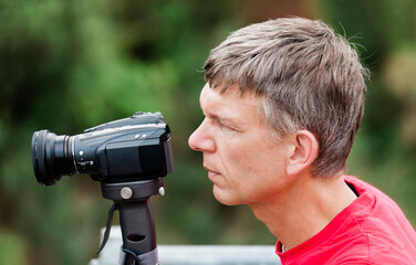 Mature man filming with camcorder