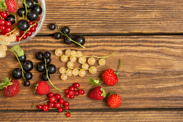 Fototapeta na wymiar Assorted berries on wooden table background with copy space. Foods rich in vitamins and antioxidants. Healthy lifestyle.