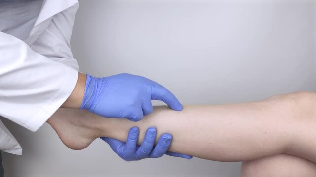 The podiatrist examines the tibia of a patient who complains of pain in it. The concept of diagnostics of bone microcracks and latent course of diseases