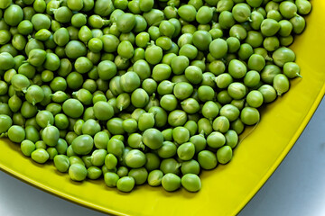 Bol verde con guisantes crudos.