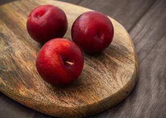 Red fresh plums on a wooden Board.