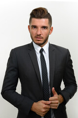 Portrait of handsome bearded Hispanic businessman in suit