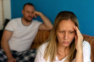 Depressed caucasian couple has dispute and are not talking while sitting at home.Couple in conflict is finding out the relationship.People,relationship difficulties,conflict and family concept.