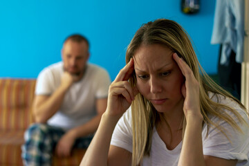 Image of an unhappy young couple having relationship problems crisis.Sad pensive young women thinking of relationship problems,sitting on sofa with offended boyfriend,conflicts in marriage.Copy space.