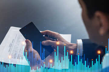 Analyst in office working with Smartphone, Data forecast graph hologram to analyze market behavior, typing phone. Double exposure.