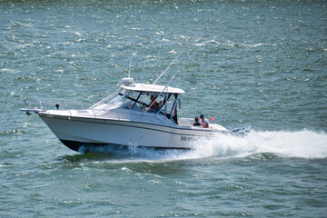 Naklejka premium Boat quickly floats on the waves on a sunny day