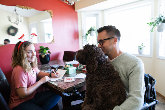 Quadriplegic man, girlfriend and pet dog preparing for Christmas