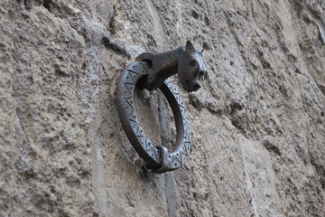 iron dragon holding an iron ring on a stone wall