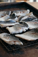 fresh raw fish filleted and sliced on a grill rack