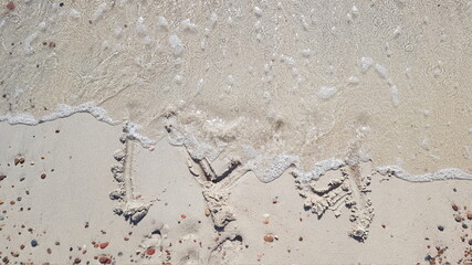 I love you saying by the sea waves about to be washed away concept iin summer