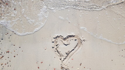 Sand heart by the ocean waves about to be washed up, love