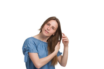 Fototapeta premium A young woman with long hair in a blue dress. Isolated on a white background