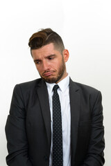 Portrait of handsome bearded Hispanic businessman in suit