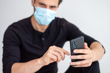 man in a medical mask 
and smartphone