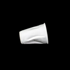 Crumpled white disposable paper plastic cup isolated on black