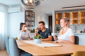 happy friends and neighbors drink tea in the dining room at home
