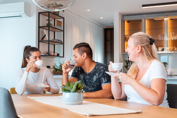 happy friends and neighbors drink tea in the dining room at home