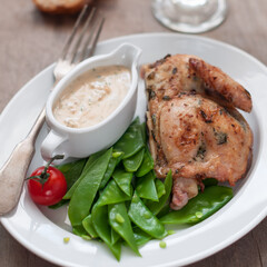 Half Roasted Chicken with Sugar Snap Peas as Side Dish and Cream Sauce