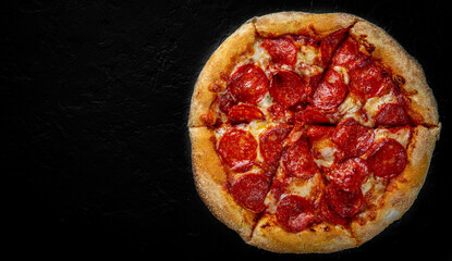 Pepperoni Pizza with Mozzarella cheese, salami, Tomato sauce, pepper, Spices. Italian pizza on Dark grey black slate background