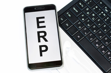 ERP CONCEPT text on the phone screen lying on the laptop keyboard