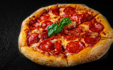 Pepperoni Pizza with Mozzarella cheese, salami, Tomato sauce, pepper, Spices. Italian pizza on Dark grey black slate background