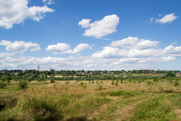 Obraz premium Countryside landscape with blue sky and white clouds.