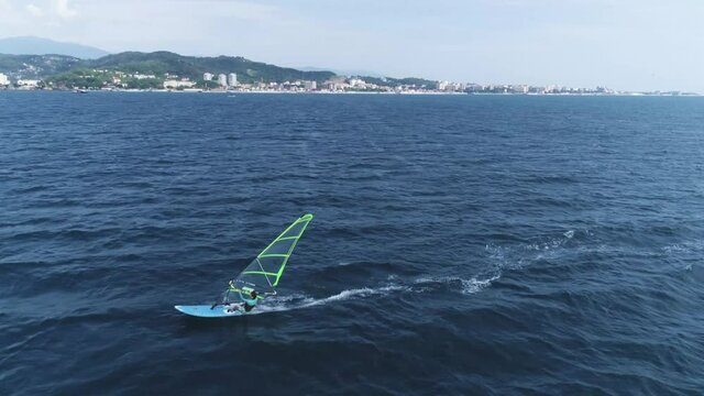A young sexy girl is riding windsurf