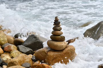 una torre de piedras redondeadas en el mar