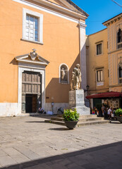 Fototapeta na wymiar Pisa, Italy - August 14, 2019: Monument to Nicola Pisano and Santa Maria del Carmine church in Pisa, Tuscany, Italy